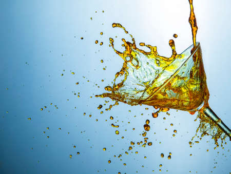 High Speed Liquids Photography. Plenty of Alcohol Drink Little Droplets Poured Out of The Clear Wine Glass.Horizontal Shotの写真素材