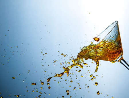 Liquids Photography. Colofur Drink Droplets Poured Out of The Clear Wine Glass.Horizontal image