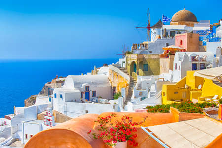 Travel Destinations. Picturesque Cityscape of Oia Village in Santorini Island Located on Volcanic Calderra at Daytime. Traditional Windmills on Background. Horizontal Imageの写真素材