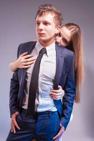 Passionate Loving Caucasian Couple Playing Together. Woman Hiding Behind Man Against Gray. Vertical Imageの写真素材