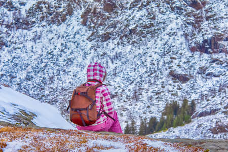 Female Photographer with Gear Sitting In Front of Snowy Mountains in Lofoten Islands in Norway. Horizontal Imageの写真素材