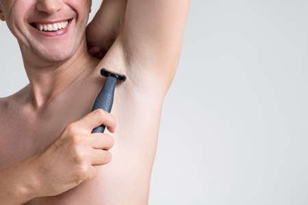 Caucasian Man Doing Undearm Hair Removal Depilation. Horizontal Imageの写真素材