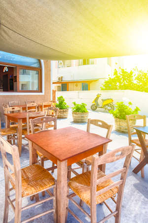 Beautiful Sunny Summer Restaurant on Santorini Island in Greece with Scooter on Background.Vertical...