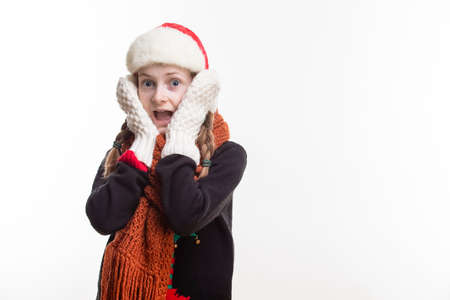 Suprised Caucasian Girl With Pigtails Posing in Winter Outfit Against Pure White in Studio....