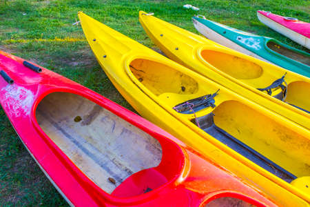 Five Colorful Plastic Kayaks Placed Together For Drying on Grass Outdoors. Horizontal Imageの写真素材