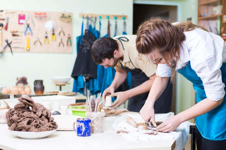 Pottering Concept. Professional Ceramists or Claymakers During a Process of Clay Preparation on Tables in Workshop. Horizontal Orientationの写真素材