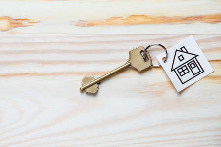 Family and Home Concepts. Home or House Symbol Along With Golden Key Over Vintage Wooden Background. Horizontal Imageの写真素材