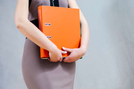 Closeup of Hands of Caucasian Female Holding Colorful office Folders. Horizontal image Composition