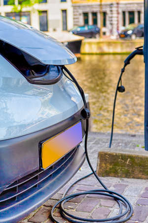 Eco-Friendly Alternative Energy Concept. Electric Car or EV Car Charging At Station With Power Cable...