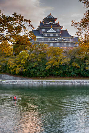 Okayama Crow Castle or Ujo Castle in Okayama City on the Asahi River in Japan. With Little Boat In...
