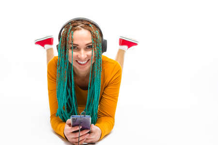 Portrait of Relaxing Caucasian Female with African American Dreadlocks Listening to Music in...