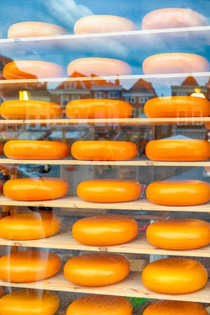 Stack of Traditional National Dutch Cheese Heads on One of The Shelves of Showcase in Old City  Delft in The Netherlands. Vertical imageの写真素材