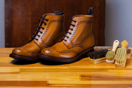 Male Fashionable Footwear Concepts. Pair of Tanned Calf Leather Derby Brogues Placed Together With Cleaning Brush Indoors. Horizontal Shotの写真素材