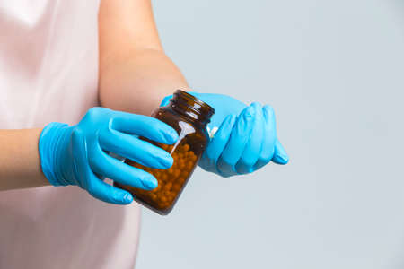 Healthcare Ideas. Hands of Caucasian Woman With Medical Pills Against Viruses. Against Gray. Horizontal Shotの写真素材