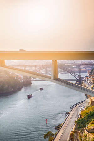Travel Places Ideas. Line of Tourist Boats and Porto Cityscape at Daytime with Ponte Infante D Henrique in Background in Portugal. Vertical Shotの写真素材