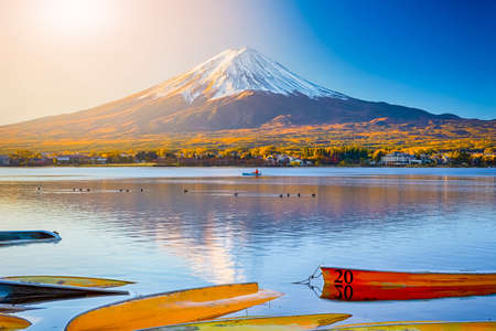 Japan Travel Destinations. Famous and Recognizable Fuji Mountain At Kawaguchiko Lake in Japan With Line of Overthrown Boats in Foregound and Fisherman in Background. Horizontal Imageの写真素材