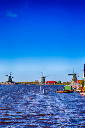 Dutch Travel Concepts. Traditional Dutch Windmills in the Village of Zaanse Schans at Daytime in the Netherlands. Vertical Image Orientationの写真素材