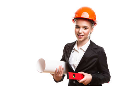 Construction Ideas. Portrait of Caucasian Teenager Girl With Drawing Paper Rolls and Measurement Level. Posing in Hard Hat Against White.Horizontal image Orientationの写真素材