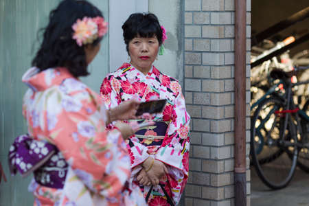 KYOTO, JAPAN - NOVEMBER, 8, 2019: Two Mature Females in Traditional Japanese Geisha's Kimono Traveling on Street of Kyoto, Japan.のeditorial素材