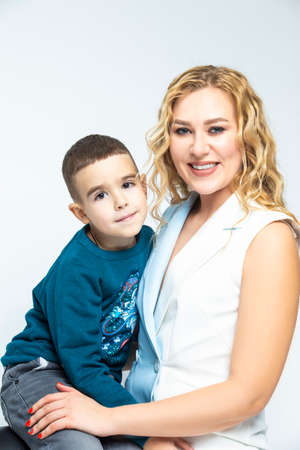 Portrait of Loving Caucasian Mother With Her Son in Studio Indoors. Posing Against White Background.Vertical imageのeditorial素材