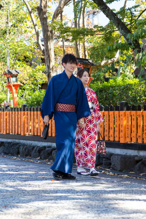 KYOTO, JAPAN - NOVEMBER, 8, 2019: Young Man and Woman in Traditional Japanese Kimono Walking in Kyoto, Japan.のeditorial素材