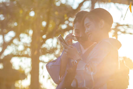 KYOTO, JAPAN - NOVEMBER, 8, 2019: Japanese Ladies Posing in Geisha Kimono and taking Pictures At One of the Kyoto Streets, Japan.のeditorial素材
