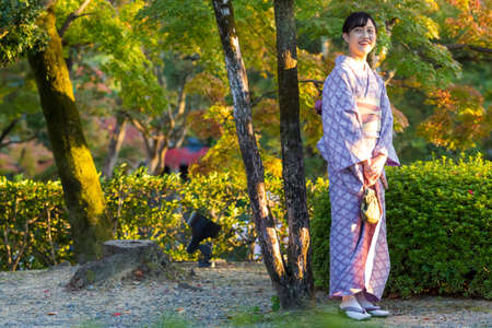 KYOTO, JAPAN - NOVEMBER, 8, 2019: Young Woman Wearing Traditional Japanese Kimono Posing in Kyoto, Japan.のeditorial素材