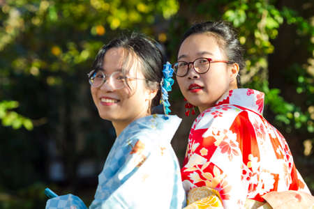 KYOTO, JAPAN - NOVEMBER, 8, 2019: Two Young Asian Girls Posing in Geisha Kimono in Traditional Japanese Environment in Kyoto, Japan.のeditorial素材