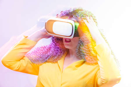 Portrait of caucasian Girl With Curly Colorful Hair Playing With VR (Virtual Reality) Helmet.Long...