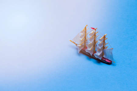 Travel Ideas and Concepts. Model of Three Masted Sailboat Placed Over Water Blue  Background with Added Suflares. Horizontal Imageの写真素材