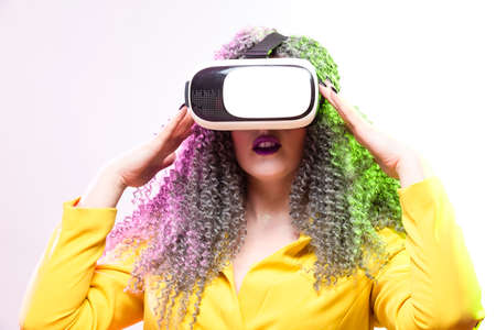 Virtual Reality Concepts. Portrait of caucasian Girl With Curly Colorful Hair Playing With VR...