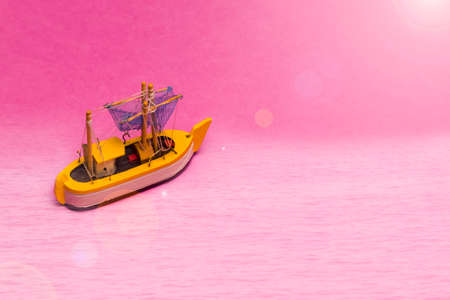 Travel Ideas and Concepts. Model of Old Sail Boat Placed Over Pink Background with Sunflares Added. Horizontal Imageの写真素材