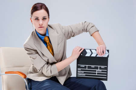 Portrait of Brunette Caucasian Woman in Shirt and Tie Posing in Chair with Actioncut. Horizontal Image Compositionの写真素材
