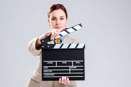 Cinema Concepts and Ideas. Portrait of Female Film Director Posing with Actioncut. Against Gray Background. Horizontal Image Compositionの写真素材