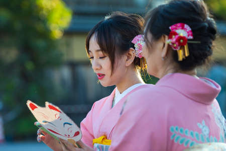 KYOTO, JAPAN - NOVEMBER, 8, 2019: Japanese Ladies Posing in Geisha Kimono At One of the Kyoto Streets, Japan.のeditorial素材