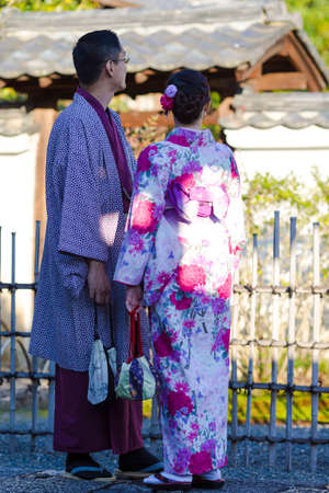 KYOTO, JAPAN - NOVEMBER, 8, 2019: Young Lovely Couple in Geisha Silk Kimono Posing On One of the Kyoto Streets, Japan.のeditorial素材