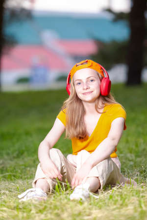 Portrait of Positive Caucasian Teenager Girl Standing on Longboard In Summer parl Outdoor. Vertical Imageの写真素材