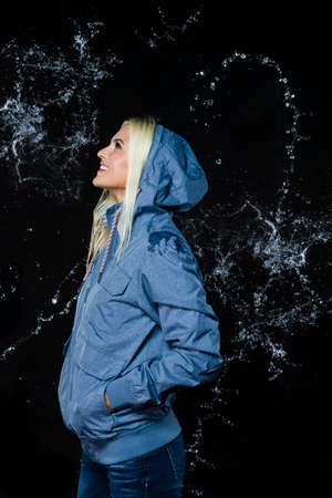 Portarit of Smiling Caucasian Blond Girl Posing In Jacket Under The Rain Drops. Vertical Imageの写真素材