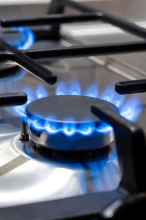 Gas Ideas and Concepts. Macro Shoot of Gas Burner on Stove Surface with Fire Flames. Vertical imageの写真素材