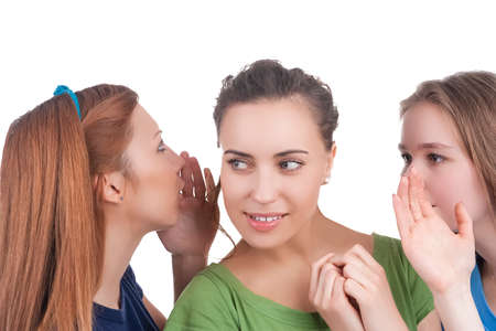 Young Caucasian Girlfriends Sharing Their Secrets Whispering to Ears.Isolated Over White Background. Horizontal Imageの写真素材