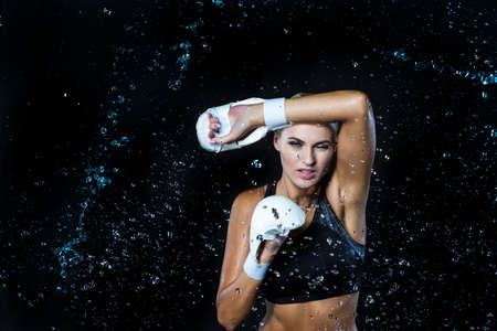 Portrait of Exhausted Professional Female Boxer  Posing in Aqua Studio Against Black Background....