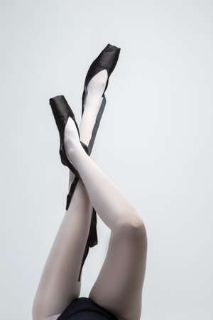 Ballet Dancer Legs In Laced Pointes Shoes. Posing With Lifted Crossed Legs. Vertical Image Compositionの写真素材