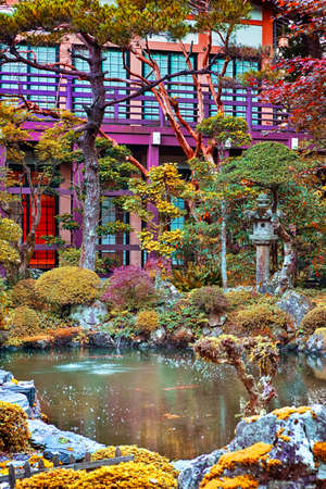 Japan Travel Concepts. Traditional japanese Garden with Red Maples, Pond and Stone Lanterns on Mount...