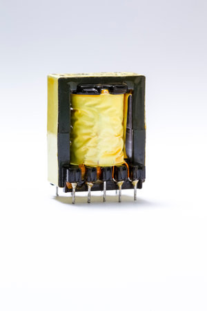 Electronics Concepts. Closeup Image of Powerful Alternative Current Voltage Transformer in Yellow Isolation Against White.の写真素材
