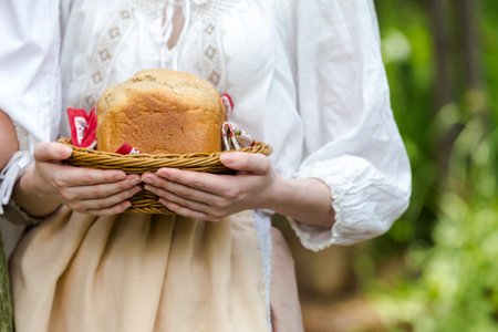 Closeup of Hands of Caucasian Girl Holding Fresh Baked Bread Outdoors.の写真素材