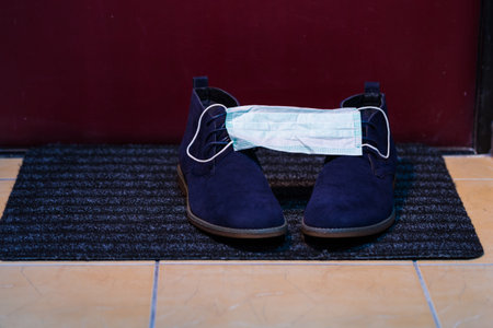 Pair of Mens Blue Suede Semi-Brogue Boots Covered With Facial Medical Mask as  protection Symbol....