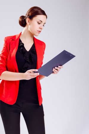 Caucasian Entrepreneur in Red Jacket Posing With Notepad In Studio. Against White. Vertical Compositionの写真素材