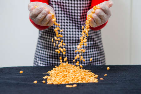 Healthcare Concepts. Closeup of Female Hands Pouring Out Wax Depilation Granules On Blue Textile Background. Horizontal Imageの写真素材
