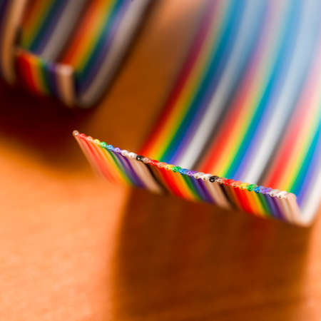 Closeup of Colorful Twisted Connecting Wire Strip on Plain Surface. Square image Composition