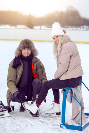 Youth Lifestyle Ideas. Happy Caucasian Couple in Winter With Ice Skates Posing Together On Snowy...